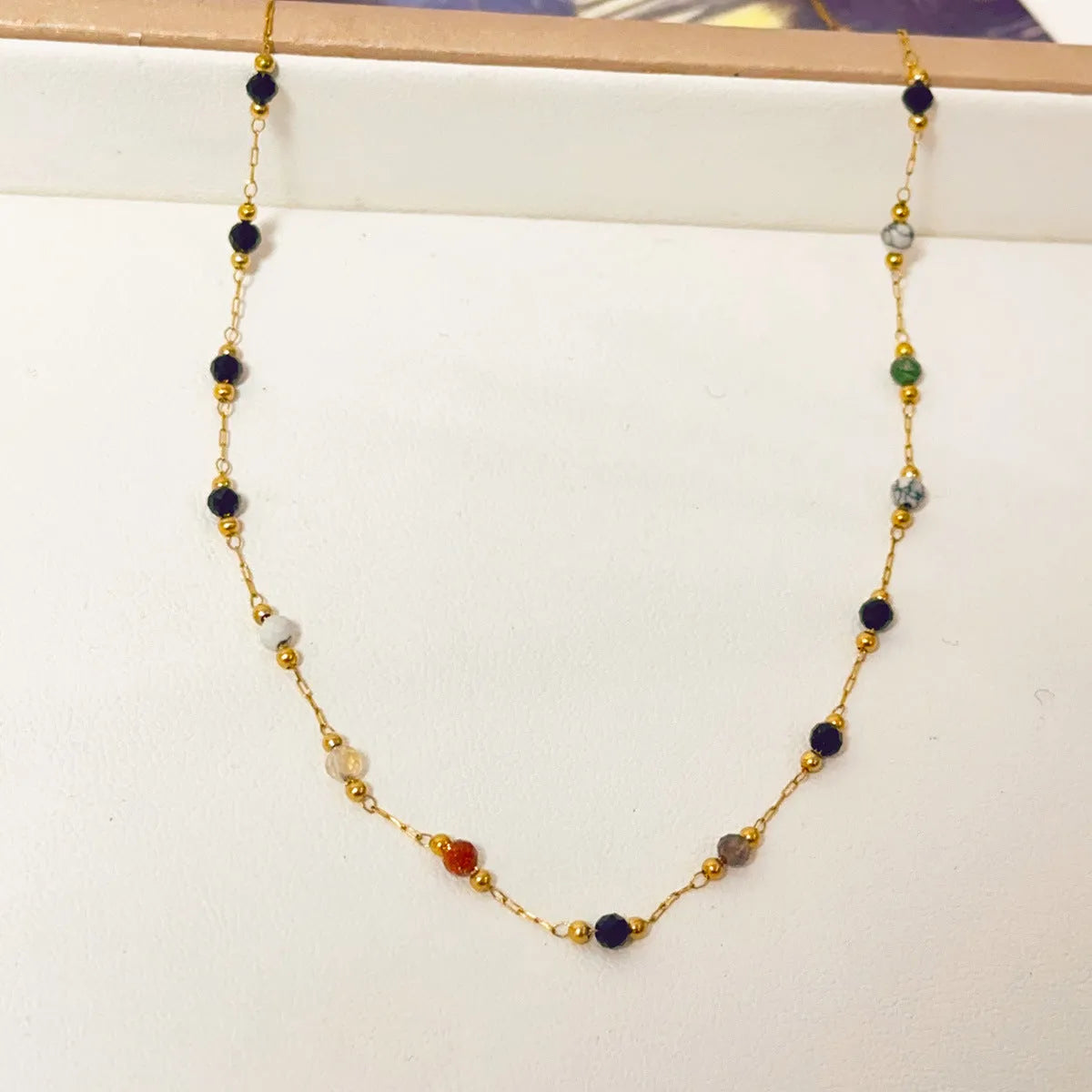 Gold electroplated titanium steel necklace for women with a natural stone pendant on an O-ring chain.