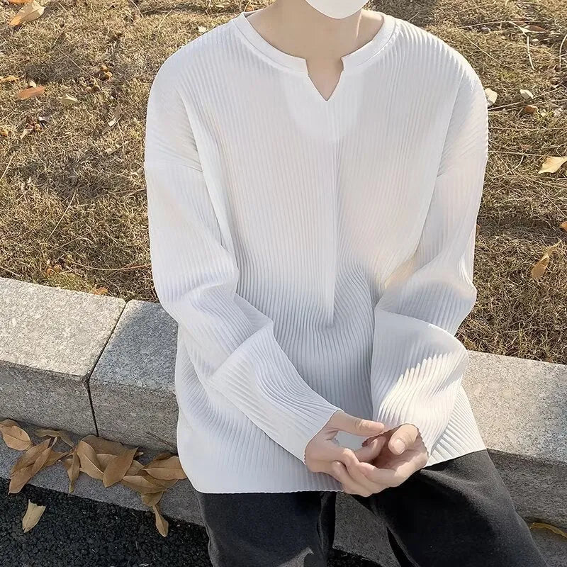 A woman wearing a black and white striped, loose-fit, long-sleeve pullover jumper.