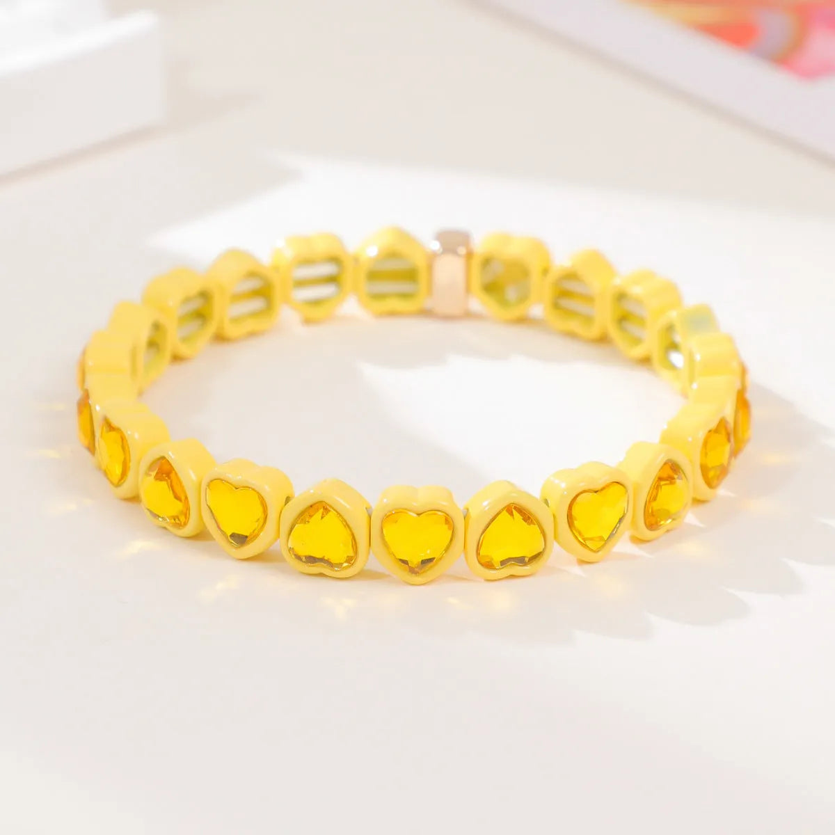 Colourful enamel heart shape on a silver-toned alloy stretch bracelet.