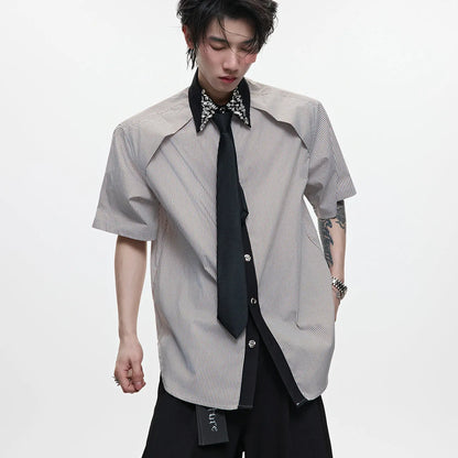 Man wearing a blue loose fit men's shirt with a diamond tie collar and patchwork striped design.