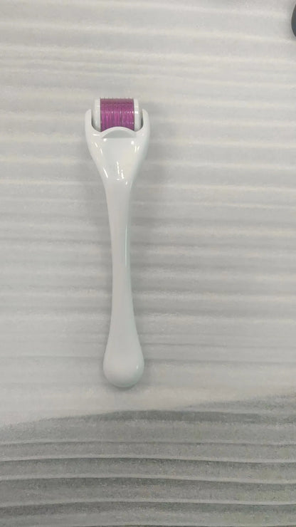 Sterile micro needle derma roller with black handle and coloured wheel on white background