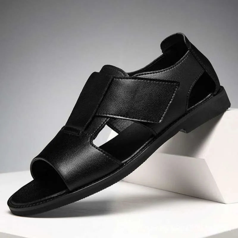 Men's brown leather Roman sandals with an open toe and rubber sole on a wooden surface.