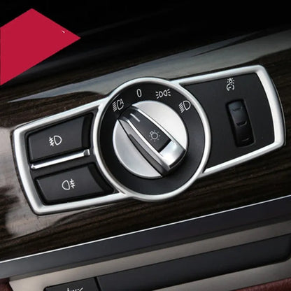 Silver ABS plastic decorative sticker for BMW headlight switch frame on dashboard.