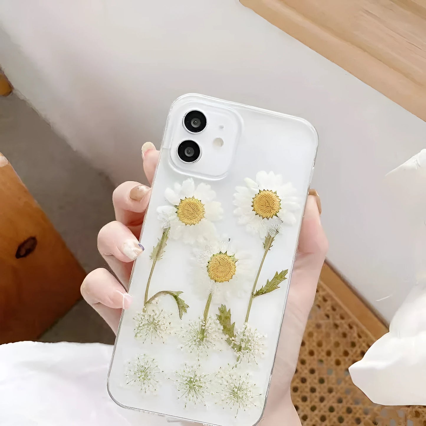 White iPhone case with a raised epoxy daisy flower pattern on the back.