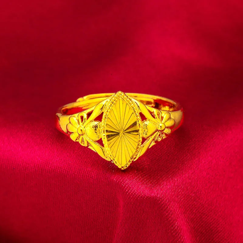 Geometric gold brass ring with open floral cut-out design and textured band, shown from the side.