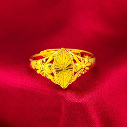 Geometric gold brass ring with open floral cut-out design and textured band, shown from the side.