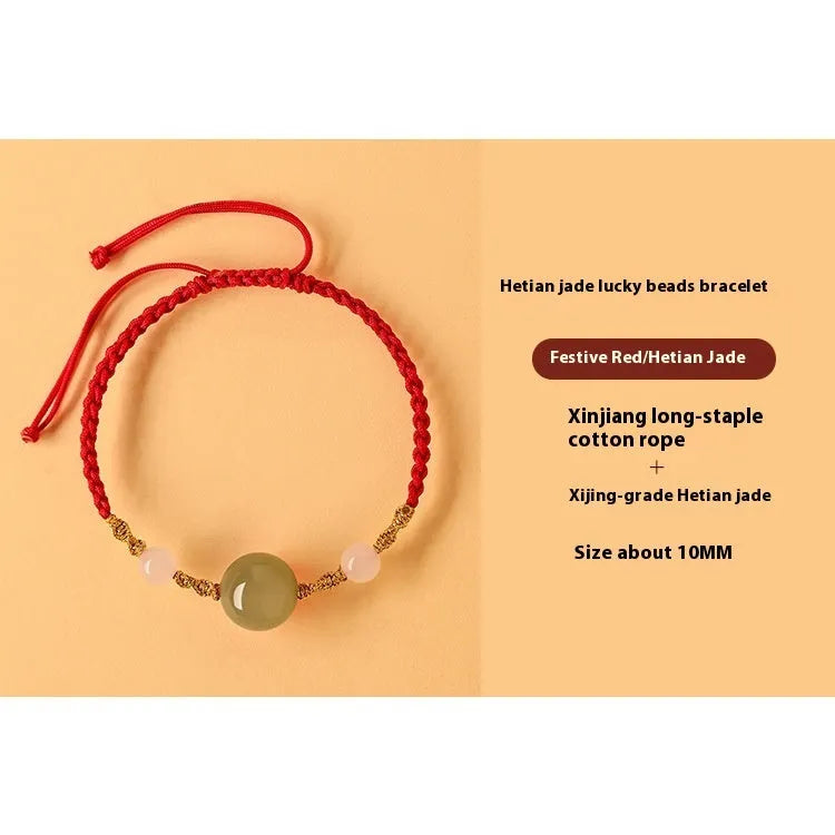 Hand-woven red rope bracelet with Hetian jade lucky beads on a wrist.