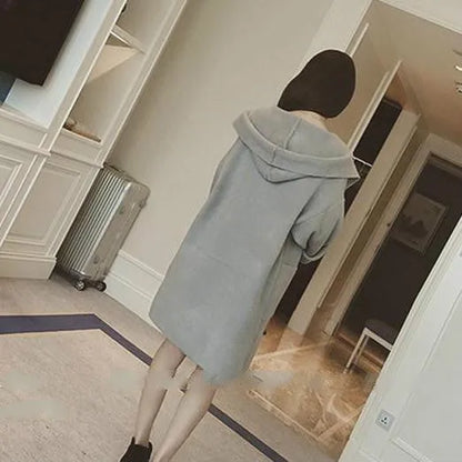Plus size woman modelling a loose fit grey thin coat with lace detailing and long sleeves.