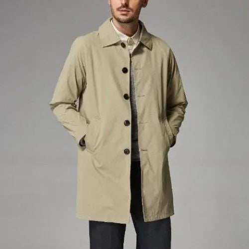 Man wearing a khaki coloured loose fit mid-length trench coat made from rabbit fur fabric.