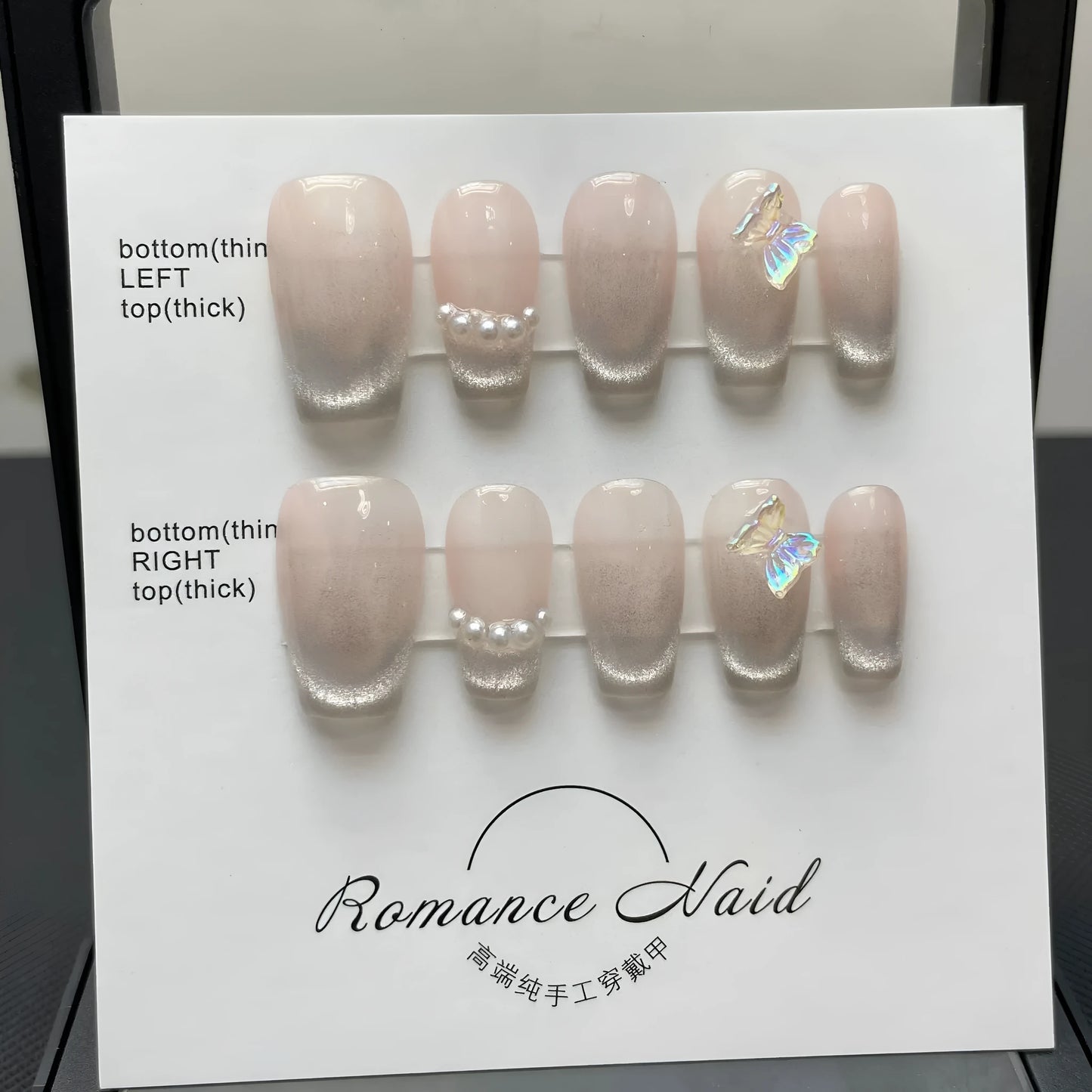 Set of short, blush-toned artificial nails in a blush armour style, laid out on a table.