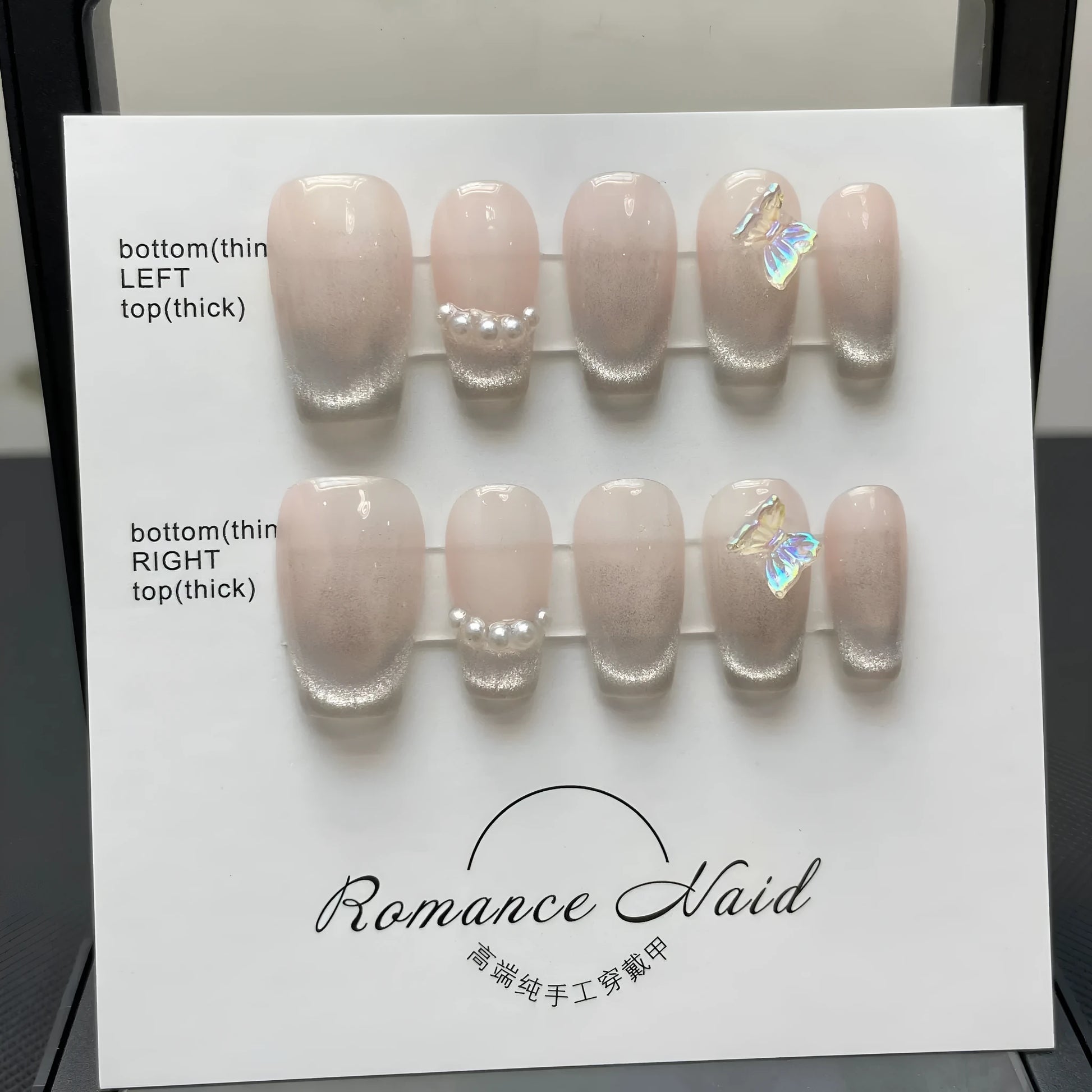 Set of short, blush-toned artificial nails in a blush armour style, laid out on a table.