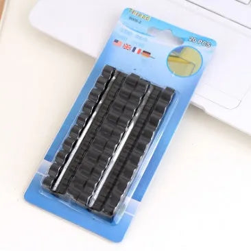 Self-adhesive plastic cable organiser clips in various colours holding a bundle of wires against a wall.