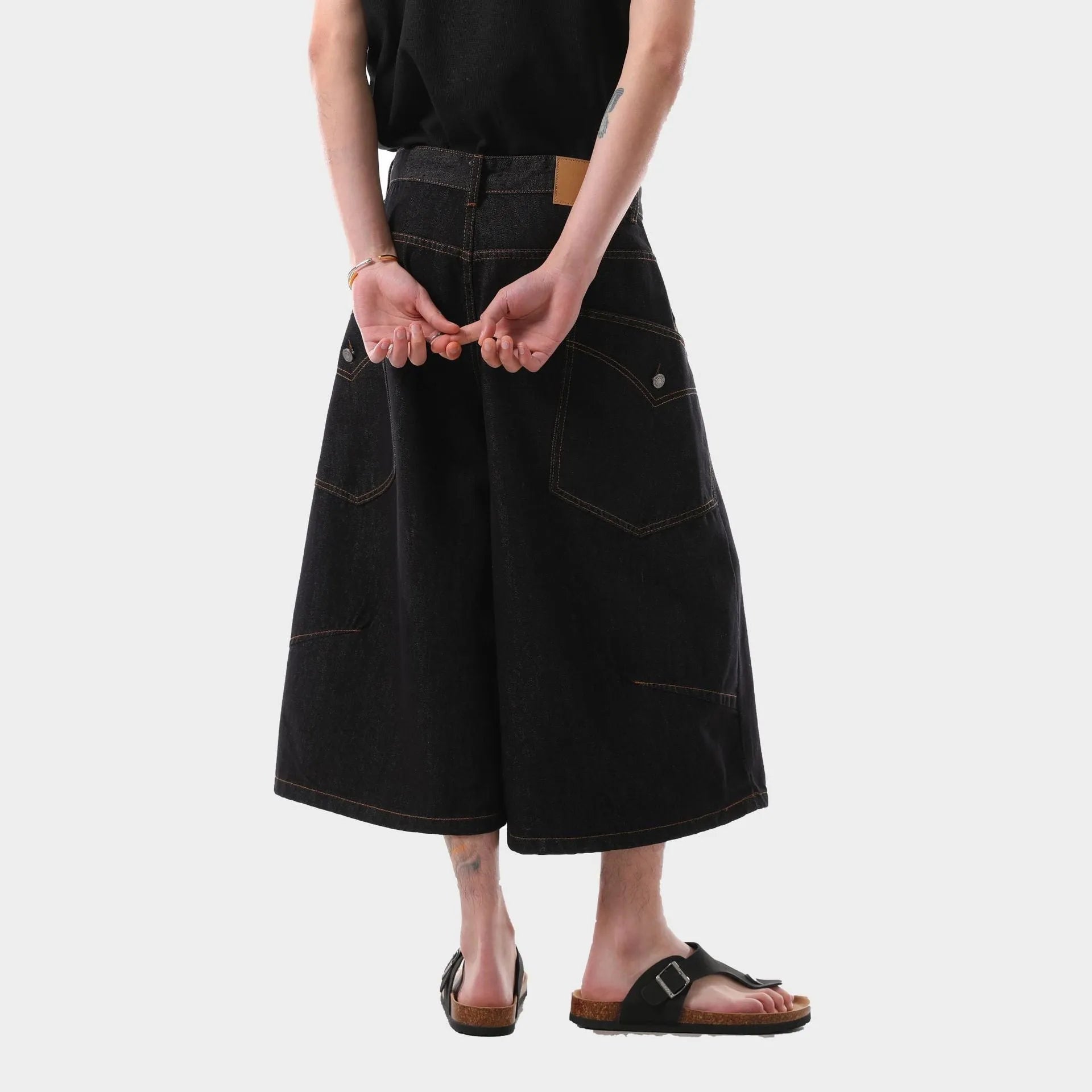 Black retro washed cropped denim trousers for men on a hanger