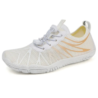 Men's and women's low-top breathable sports running shoes with a natural rubber sole on a hard ground surface.