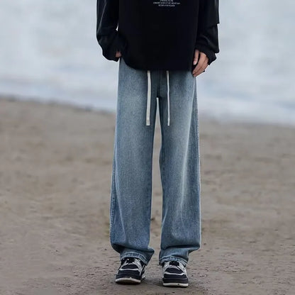 Men's blue straight-leg denim trousers with drawstring waist shown on hanger