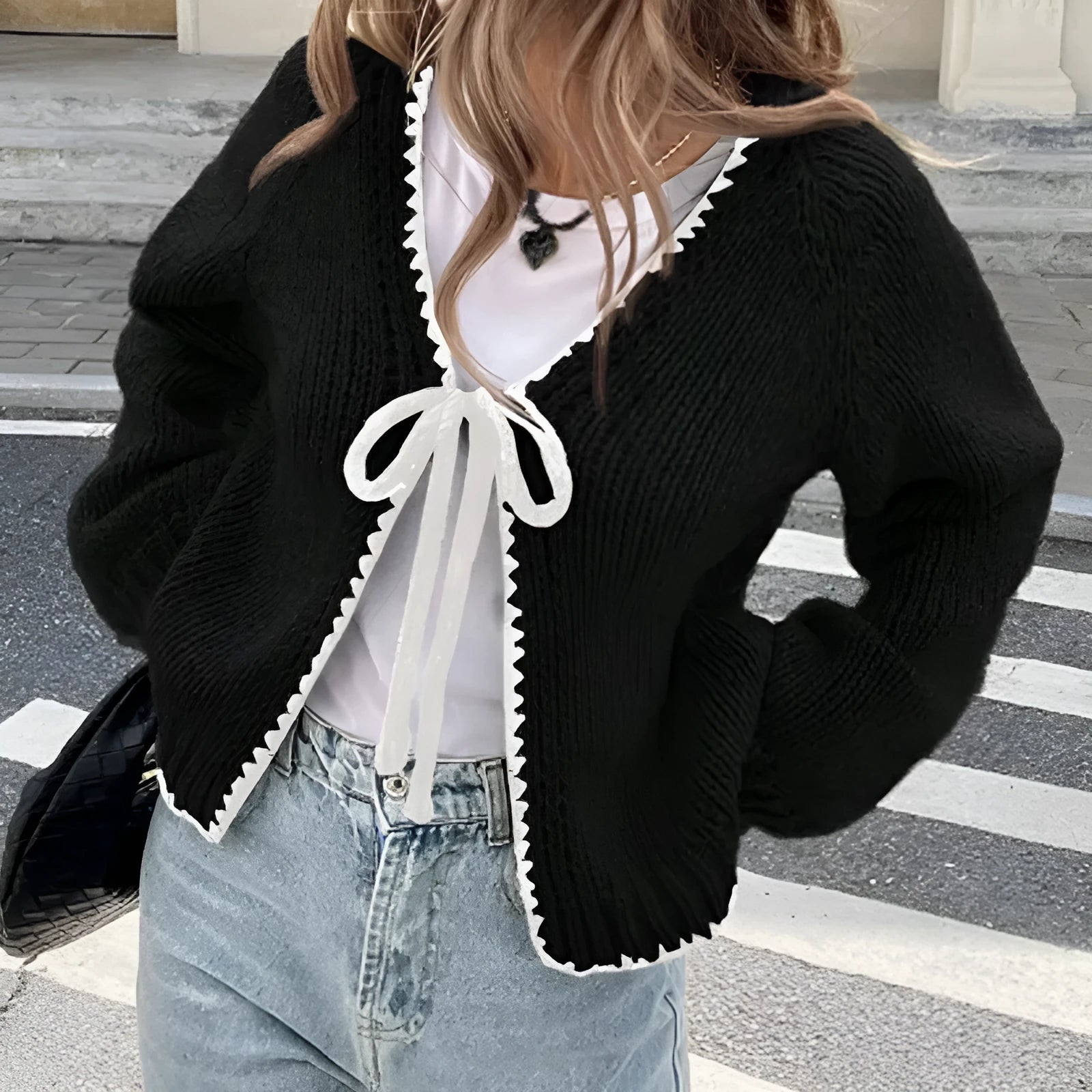 Grey lace-up front cardigan sweater with long sleeves and a crocheted flower detail.