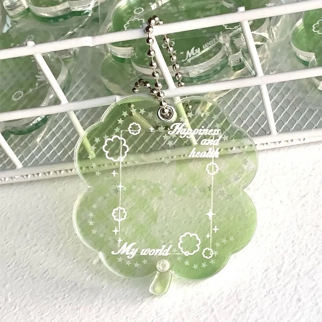 Four-leaf clover shaped acrylic phone pendant keychain in blue, green, and mint colour options