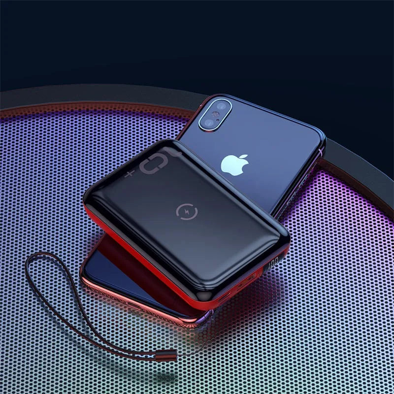 Small square black wireless charging power bank with LED display showing battery percentage.