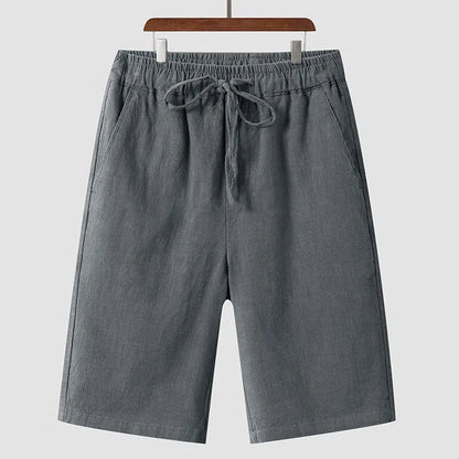 Men's beige linen casual shorts with a loose fit and elastic waistband on a neutral background.