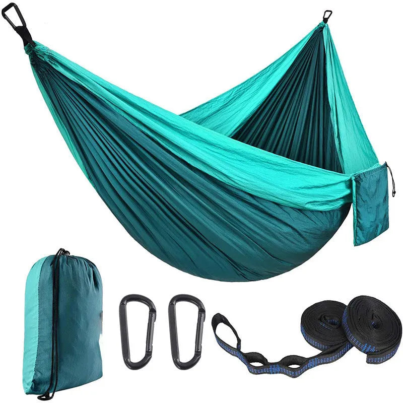 Parachute cloth double camping hammock in chosen colour, with black buckles and round ropes on a tree.
