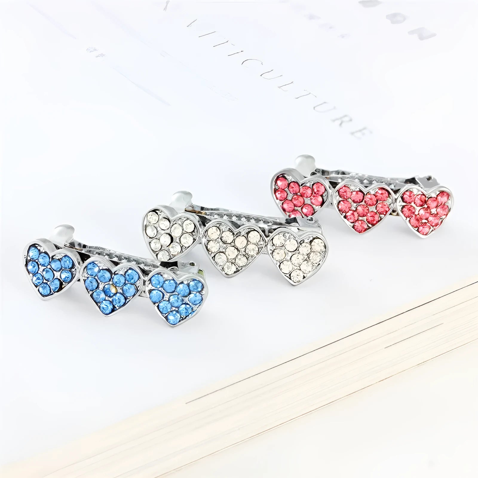 A 3cm long peach heart shaped hair clip with rhinestones and a small dog charm, on a white background.