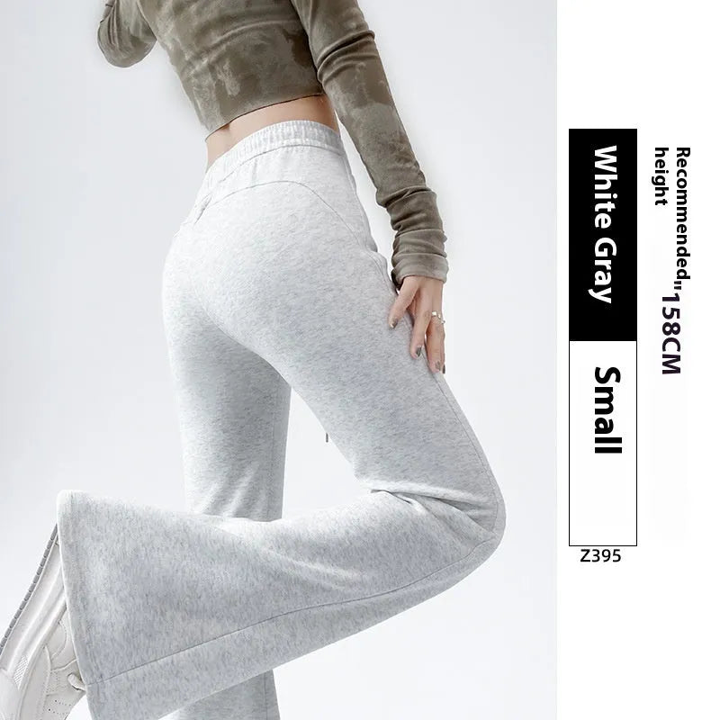 Women's high waist bootcut sports pants in black cotton with fleece lining and micro elasticity, slightly flared leg.