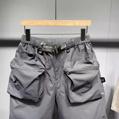Men's black loose-fit work shorts with multiple pockets showing mid-waist design