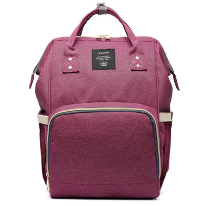 Stylish maternity diaper bag in various colors, featuring a paper bag design, separate bottle compartment, and discreet breastfeeding button.