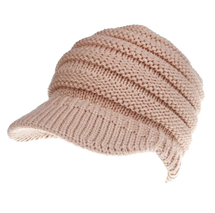Women's acrylic knitted ponytail beanie in a solid colour, shown on a model with a ponytail.