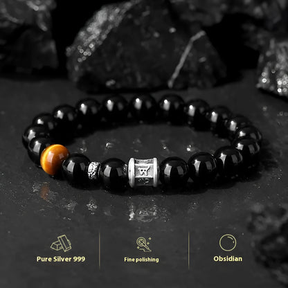 Men's black obsidian bracelet with 10mm prayer wheel beads and silver accents showing hand-woven construction