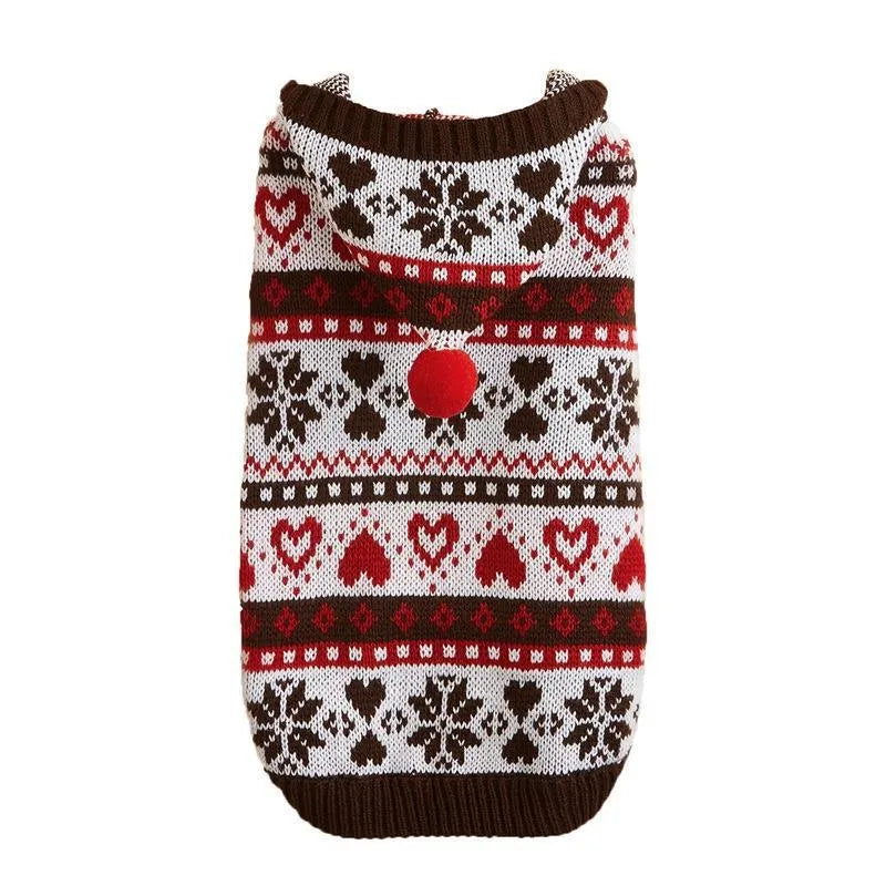 Small dog wearing a pink camouflage patterned knitted sweater with snowflake and heart stripes.