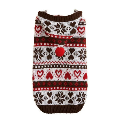 Small dog wearing a pink camouflage patterned knitted sweater with snowflake and heart stripes.
