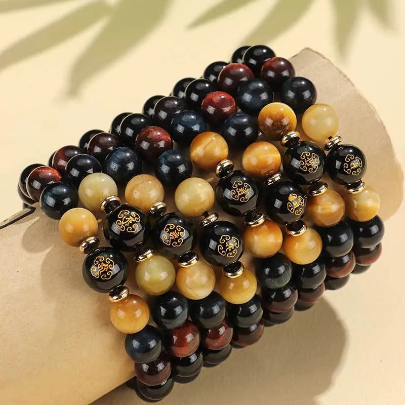 Handcrafted black agate and tiger eye stone beaded bracelet with a central carved zodiac deity charm.