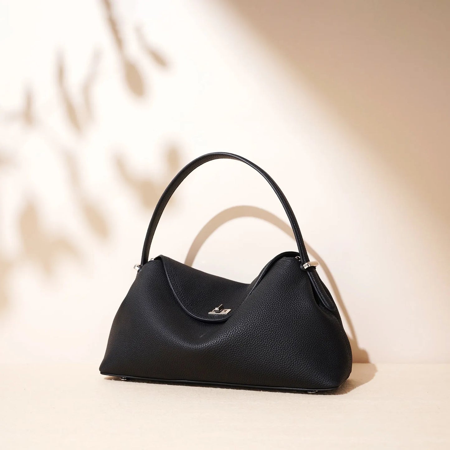 Cowhide leather shoulder messenger bag in a pillow shape with an open pocket and adjustable double straps.