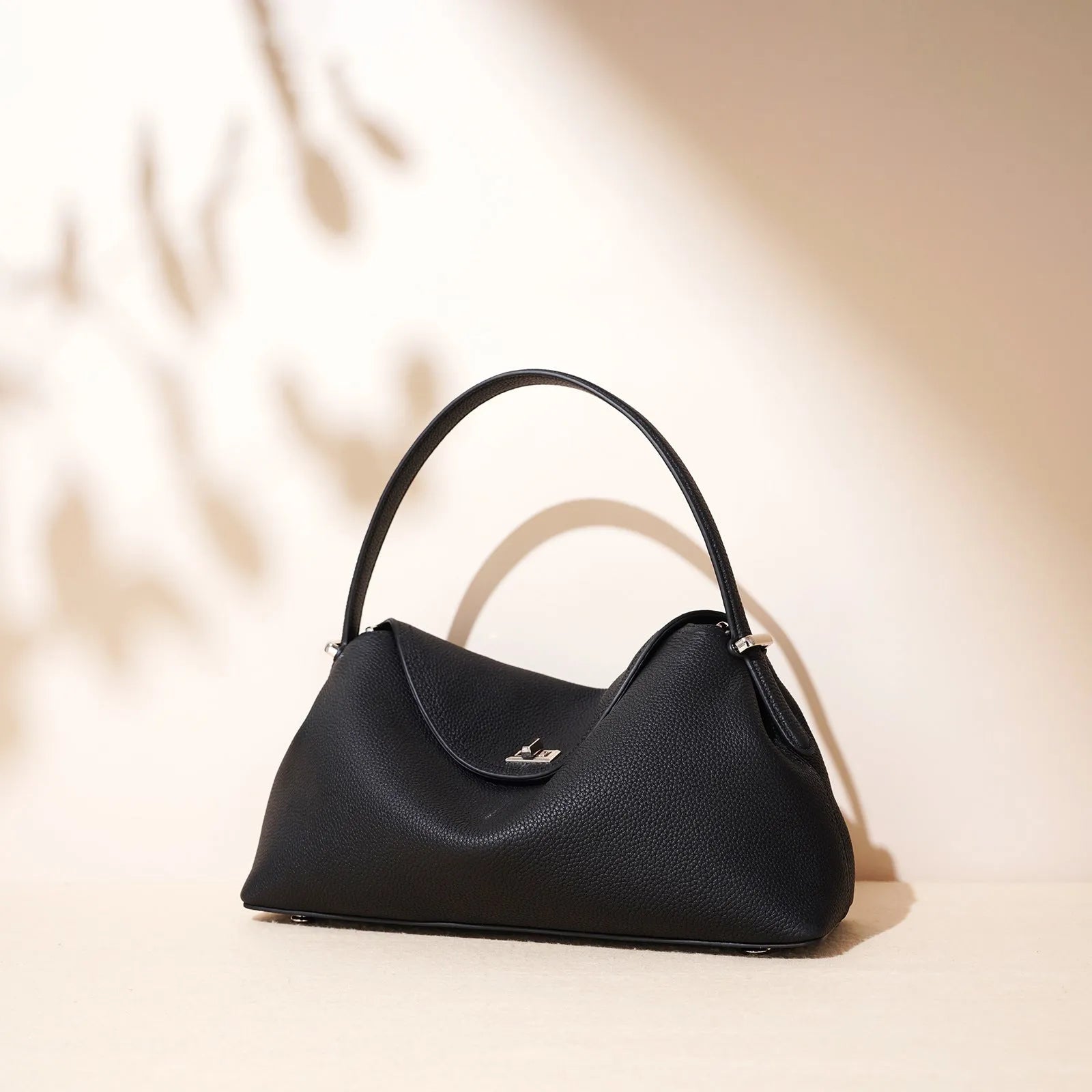 Cowhide leather shoulder messenger bag in a pillow shape with an open pocket and adjustable double straps.
