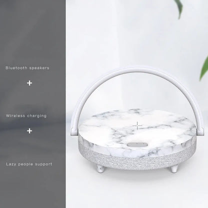 Wireless charging LED night light with Bluetooth speaker in marble pattern finish on bedside table