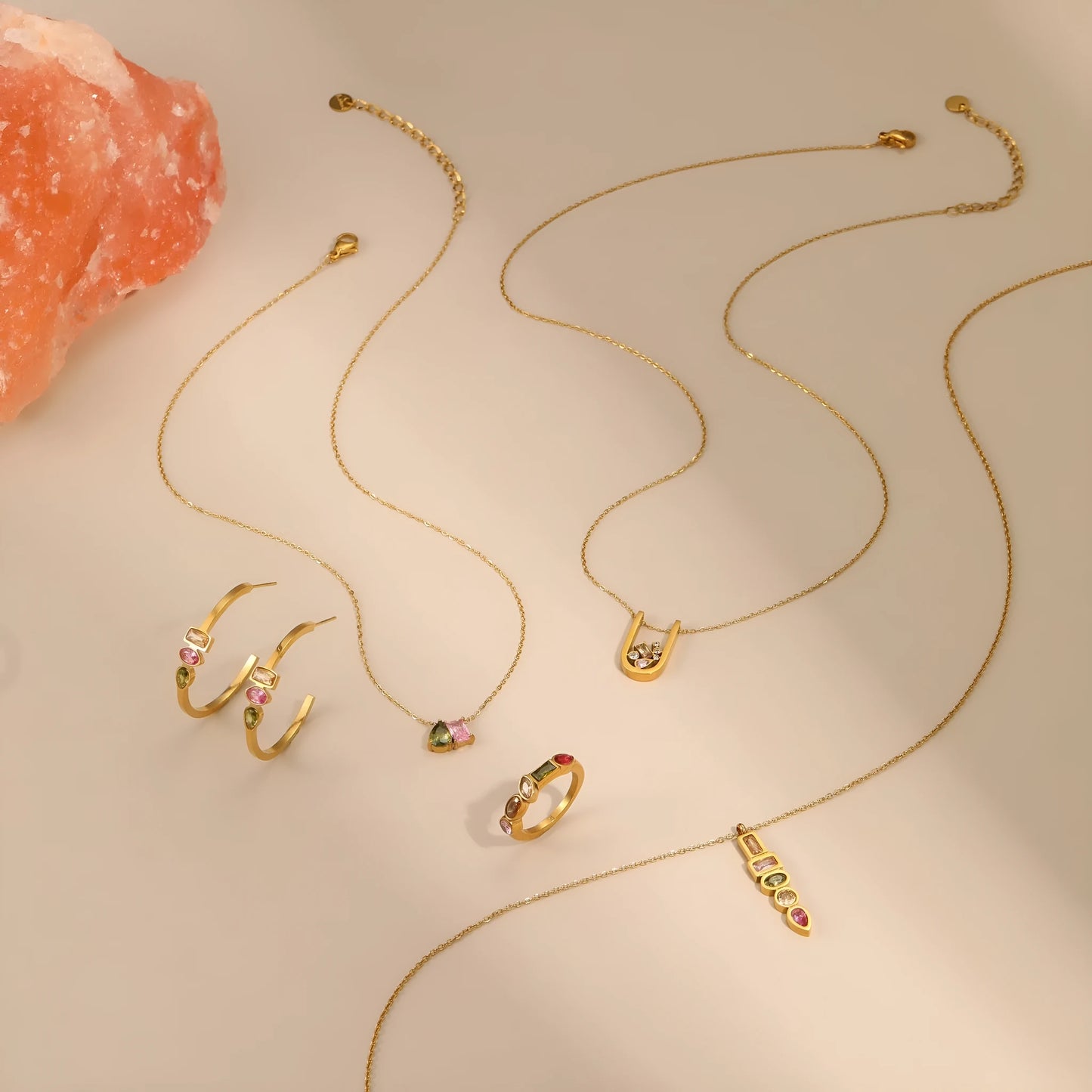 Gold geometric jewellery set with colour zircon accents showing necklace, ring, and earrings