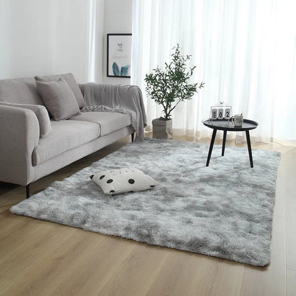 Soft fluffy plain rectangle carpet with anti-slip dots on backing, shown in a light grey colour on a wooden floor.
