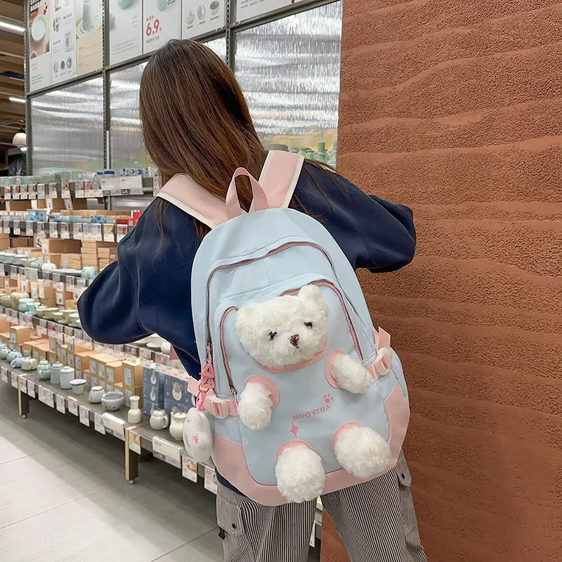 Macaron colour nylon school backpack with curved straps, shown in yellow pink, with a pendant attached.