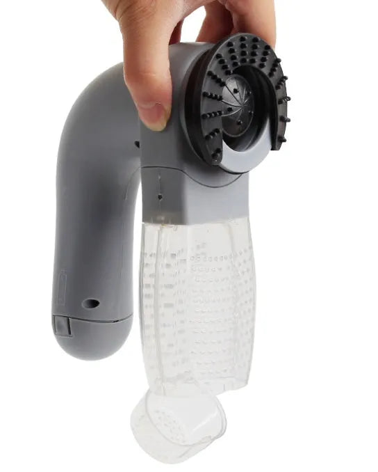 Grey handheld electric pet hair remover brush with soft rubber head for grooming dogs and cats.