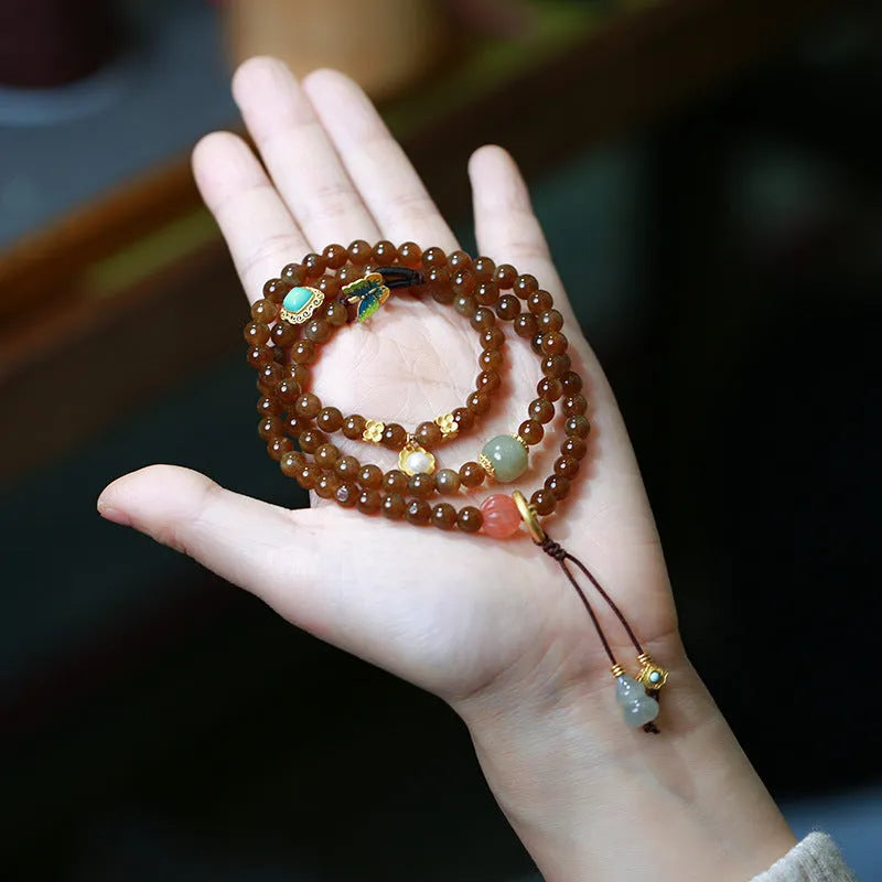 Brown jade women's bracelet with silver butterfly charm and three-ring design.