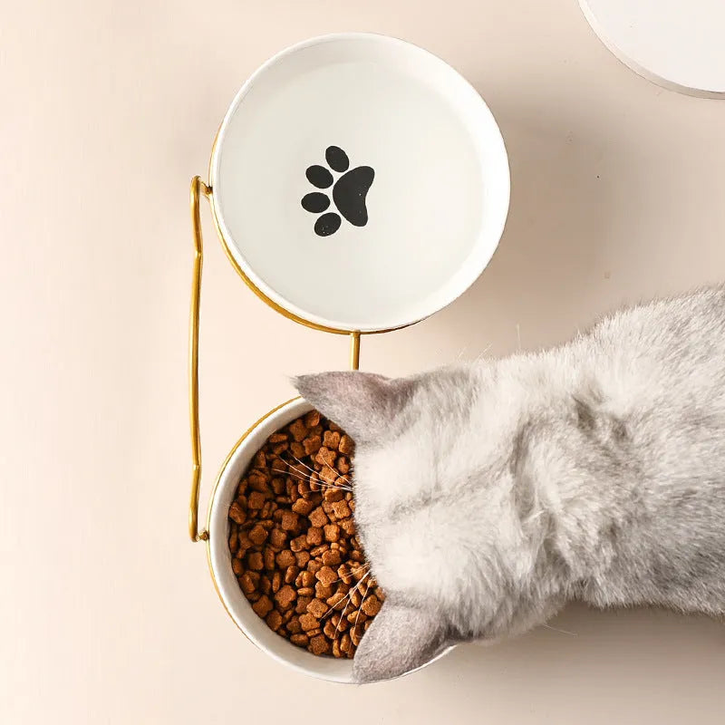 White ceramic pet bowl with cat paw print in a black iron stand with cat ear details