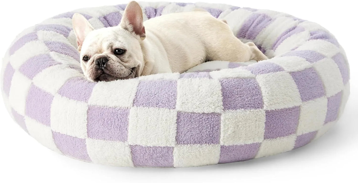Round blue and white plaid dog bed with plastic sides on wooden floor