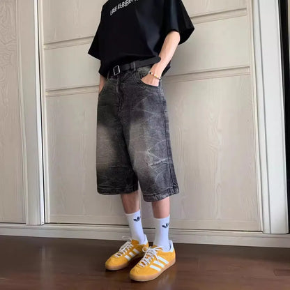 Man wearing loose light blue washed denim shorts with a straight leg and cropped length.