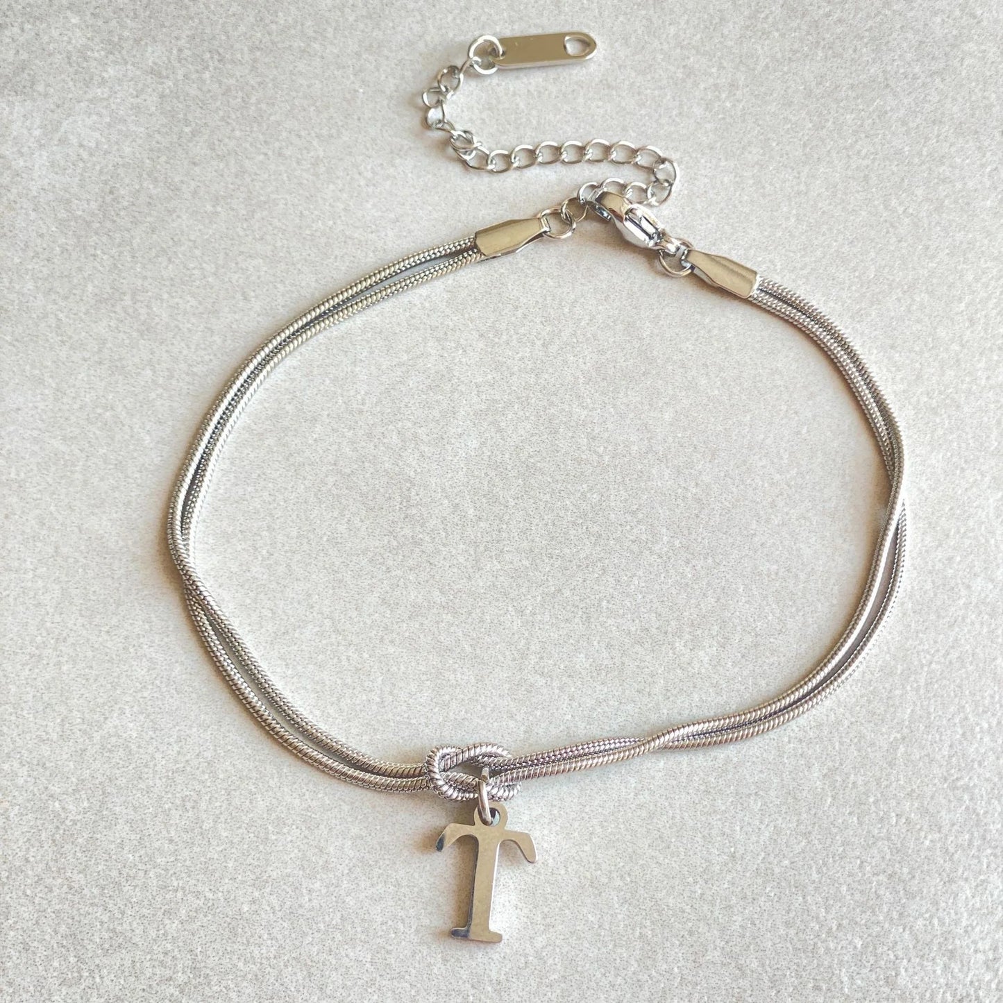 Elegant letter charm bracelets for women in gold and silver tones, featuring a delicate snake chain design and personalised letter charms.