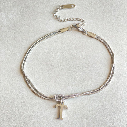 Elegant letter charm bracelets for women in gold and silver tones, featuring a delicate snake chain design and personalised letter charms.
