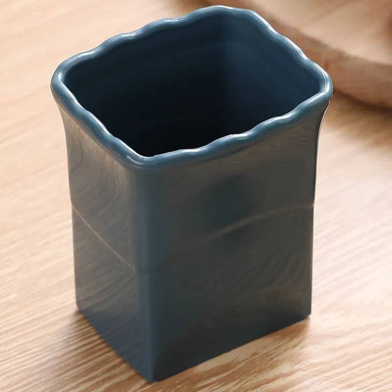 Green stainless steel cup-shaped kitchen slicer for cutting fruits and eggs on a countertop.