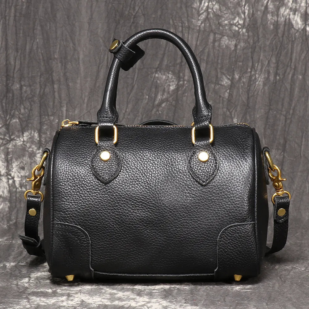 Handmade cylindrical brown Boston bag made from first layer cowhide leather with a single shoulder strap.