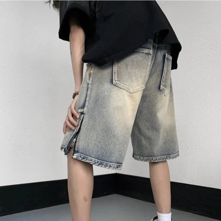 A pair of faded blue denim shorts with a tattered, distressed finish and a loose wide-leg silhouette.