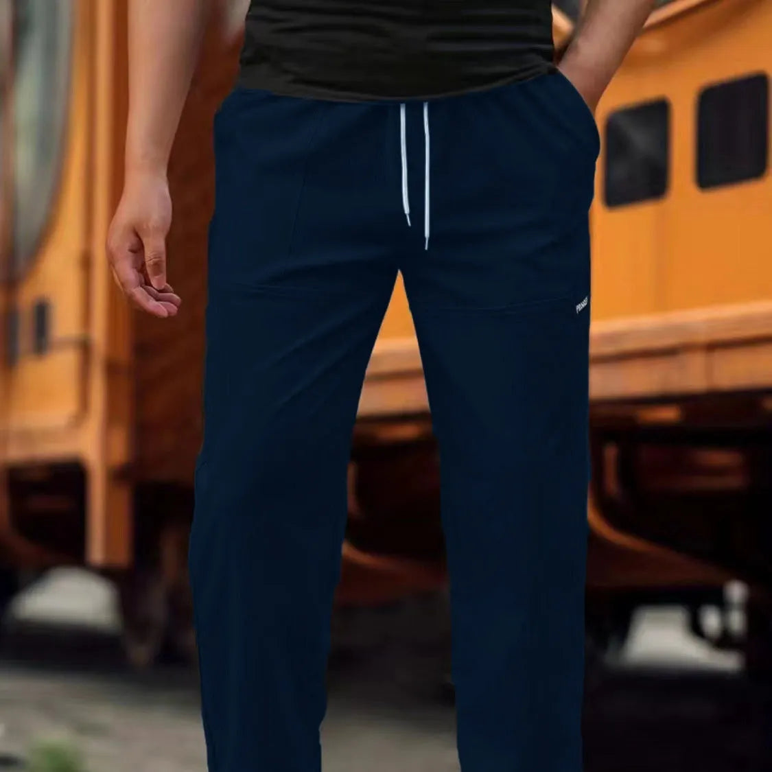Men's light grey polyester trousers with an elasticated waistband laid flat